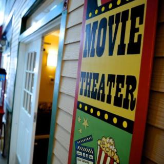 A vintage-style movie theater sign with popcorn illustration.