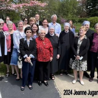 A group of people gathered outdoors for a photo, labeled '2024 Jeanne Jugan'.
