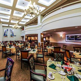 A well-appointed dining area with elegantly set tables and chandeliers.