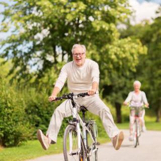 Elderly man enjoying a fun bike ride in the park.
