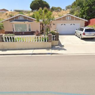 A suburban house with a driveway and parked car.