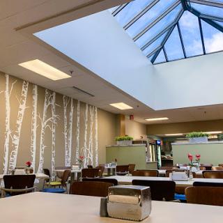A bright and inviting dining area featuring a skylight and elegant decor.
