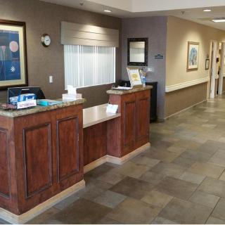 A welcoming reception area with a wooden desk and tiled flooring.