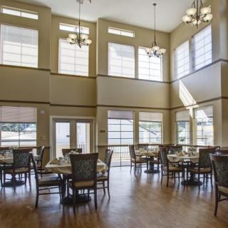 A spacious dining area with large windows and elegant chandeliers.