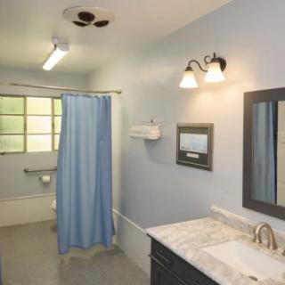 A clean and simple bathroom with light blue walls and a blue shower curtain.