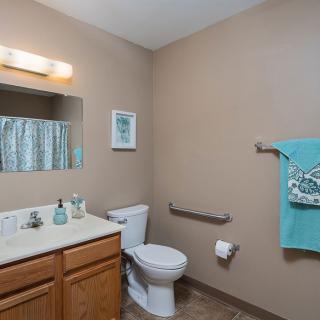 A neatly organized bathroom with a toilet, sink, and mirror.