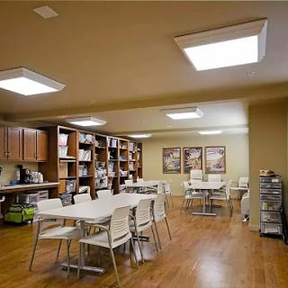 A spacious dining area featuring modern furniture, warm lighting, and wooden flooring.