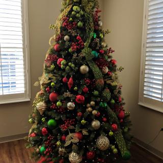 A beautifully decorated Christmas tree adorned with colorful ornaments and ribbons, bringing holiday cheer to the room.