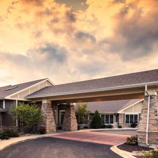 A modern building with a welcoming entrance under a dramatic sunset sky.