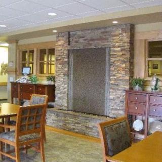 A cozy lobby area featuring a stone fireplace and wooden furniture, perfect for relaxation.