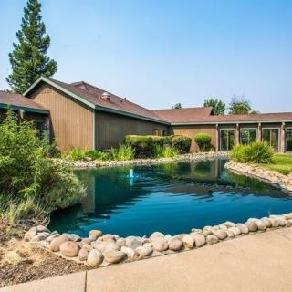 A landscaped garden featuring a pond beside a house.