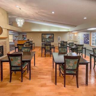 A spacious dining area with multiple tables and chairs on a hardwood floor.
