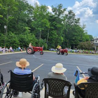 Residents enjoy a lively tractor parade on a sunny day.