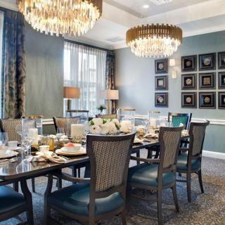 A luxurious dining room with elegant chandeliers and a beautifully set table.