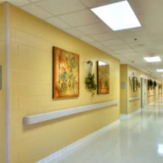 A well-lit hospital corridor featuring artwork on the walls.