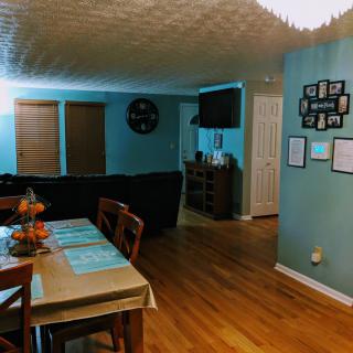 Cozy dining and living room with blue walls and wooden flooring.