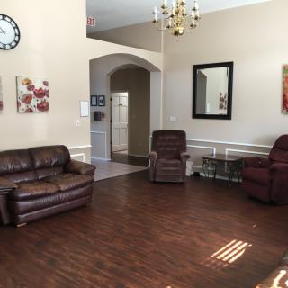 A cozy living room with leather furniture, a wall clock, and decorative elements.