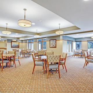 A spacious and well-lit dining area with wooden tables and chairs, designed for comfort.