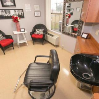 A cozy salon interior with a haircut station and waiting area.