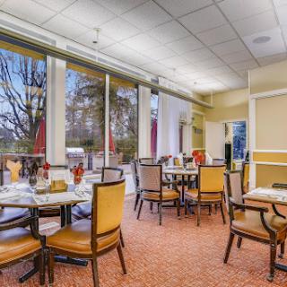A well-lit dining area featuring tables and chairs, perfect for a restaurant setting.