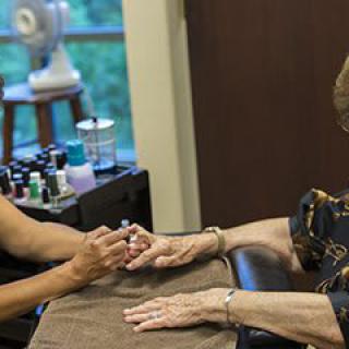 A person receiving a manicure at a nail salon.