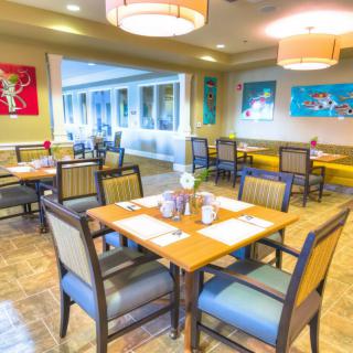 A bright and inviting dining area with neatly arranged tables and chairs.