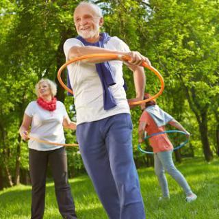 Seniors enjoying a fun hula hoop session in the park.