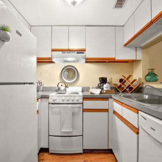 A compact kitchen with white cabinets and modern appliances.