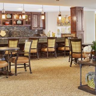A cozy interior with a bar and seating area featuring comfortable furniture and warm lighting.