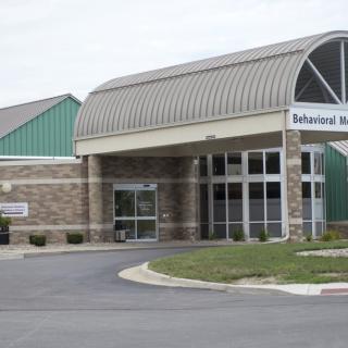 The entrance to a healthcare facility with a sign labeled 'Behavioral Health'.