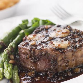 Grilled steak served with asparagus on a white plate.