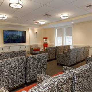 A well-furnished waiting room with multiple seating arrangements and a television.
