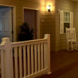 An indoor setting resembling an outdoor porch with a rocking chair and soft lighting.