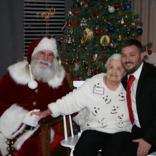 A joyful family photo with Santa Claus in front of a beautifully decorated Christmas tree.