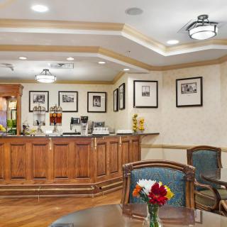 A warm and welcoming hotel lobby featuring a wooden reception desk, comfortable seating, and elegant decor.