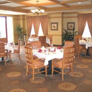 An elegantly set dining area with neatly arranged tables and chairs in a refined restaurant environment.