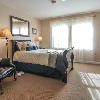 A cozy bedroom with a large bed, bedside lamps, and a mirror on the wall.