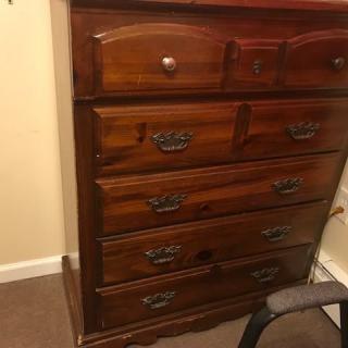 A wooden chest of drawers in a room.