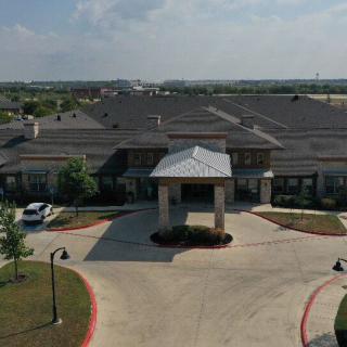 A large building with a main entrance and surrounding landscape.