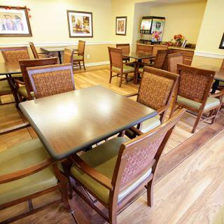 An empty dining area with neatly arranged tables and chairs, ready for guests.