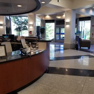 A spacious reception area featuring a modern design with ample seating and natural light.