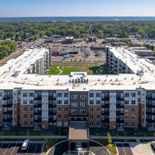 Aerial view of a modern apartment complex with a spacious courtyard in an urban area.