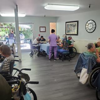 A vibrant community setting in a nursing home where staff engage with residents during an activity.