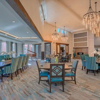 A elegantly designed dining area with chandeliers and comfortable seating.