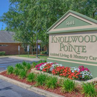 Entrance sign for Knollwood Pointe Assisted Living & Memory Care surrounded by landscaped flowers.