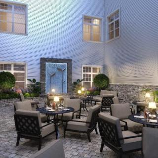 A cozy courtyard with elegant outdoor seating and soft lighting, perfect for a relaxing evening.