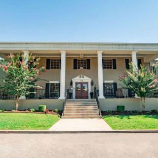 A large building with prominent columns and a well-maintained lawn.