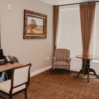 Cozy office space with a desk, chair, and window with curtains.