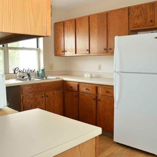 A cozy kitchen with wooden cabinets and a white refrigerator.