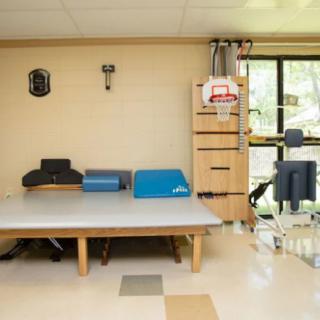 A physical therapy room equipped with rehabilitation tools and an exercise mat.
